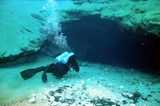 scuba diver at depth at the mouth of a spring head cave.