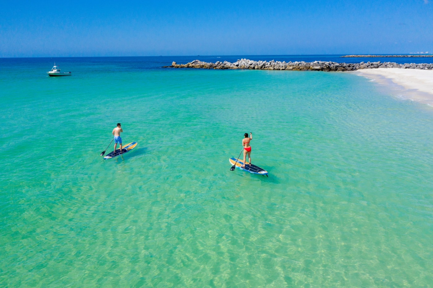 people paddling in the gulf near the jetties.