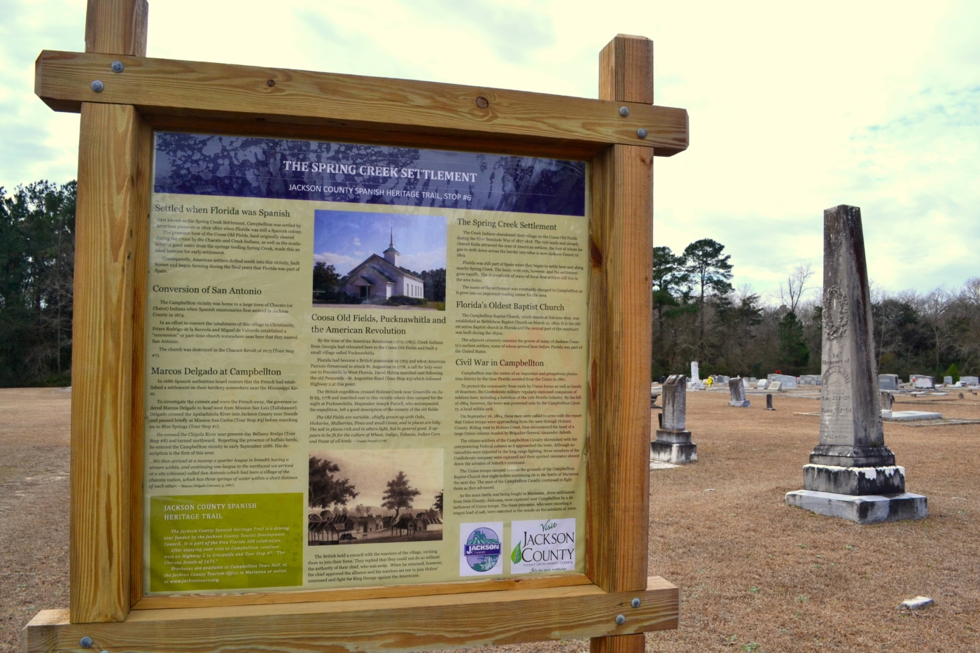 Spring Creek Settlement sign in front of a cemetery.