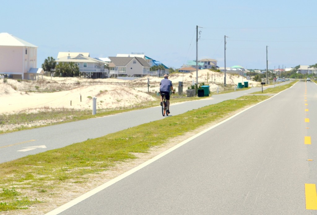 Image of someone biking down St. George Island sidewalk.