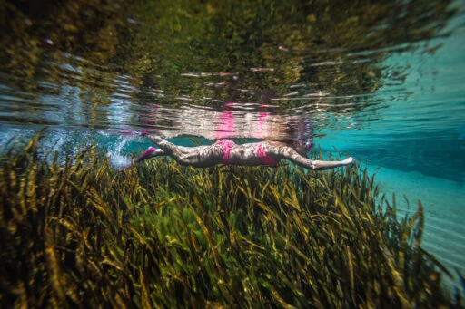 Image of a woman swimming beneath the water of Blue Springs.